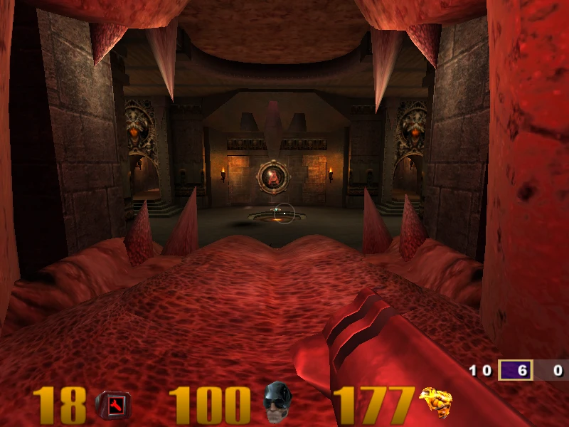 Spieler zielt aus dem geöffneten roten Maul eines Monsters auf ein feuriges Arena-Interieur in Quake III Arena