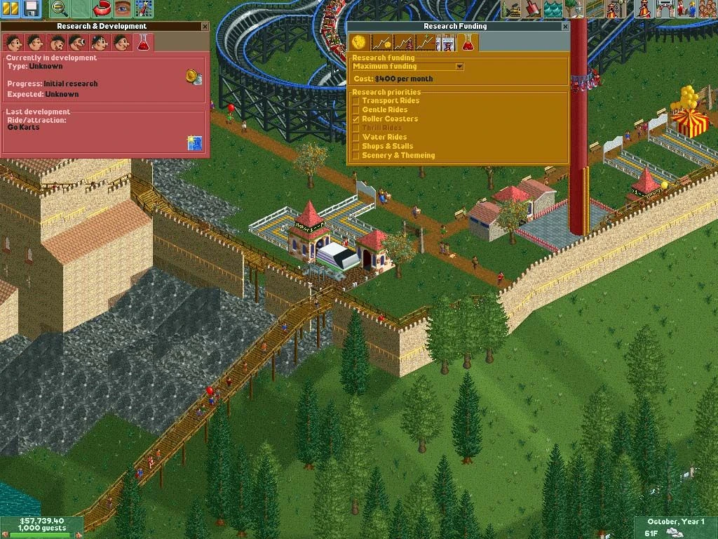 Juego de RollerCoaster Tycoon 2 mostrando ventanas de investigación y financiación con castillo y vía de montaña rusa