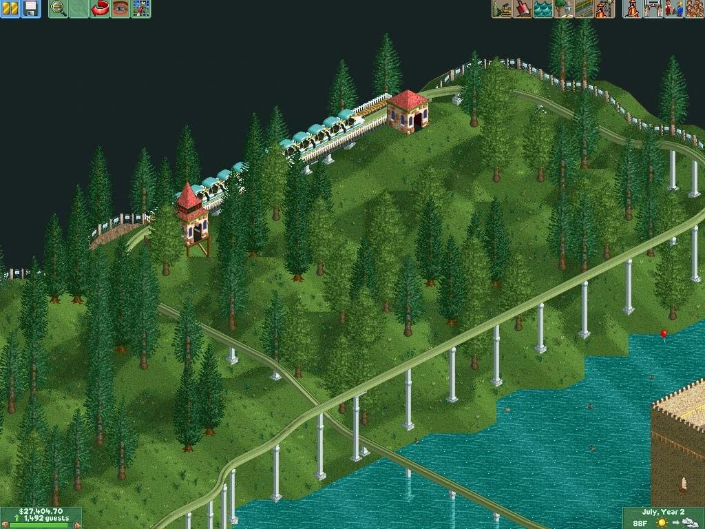 Vía elevada de monorraíl atraviesa pinos en una colina junto al agua con plataformas de estación