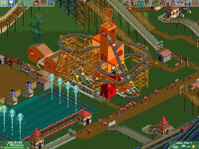 Vista isométrica de montaña rusa de madera junto a lago con fuentes y visitantes en RollerCoaster Tycoon 2