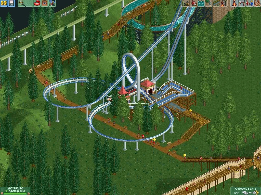 Vista cenital de una montaña rusa con loop y pasarelas de madera en un entorno boscoso