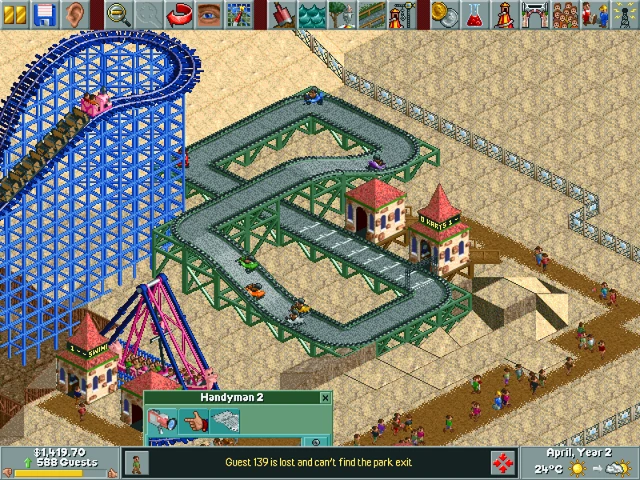 Rozgrywka RollerCoaster Tycoon z drewnianą kolejką górską, torem gokartowym i gośćmi w tematyce pustynnej