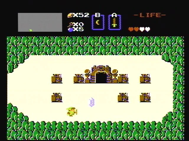 Captura de pantalla de The Legend of Zelda mostrando a Link cerca de la entrada de una mazmorra rodeada de árboles y obstáculos