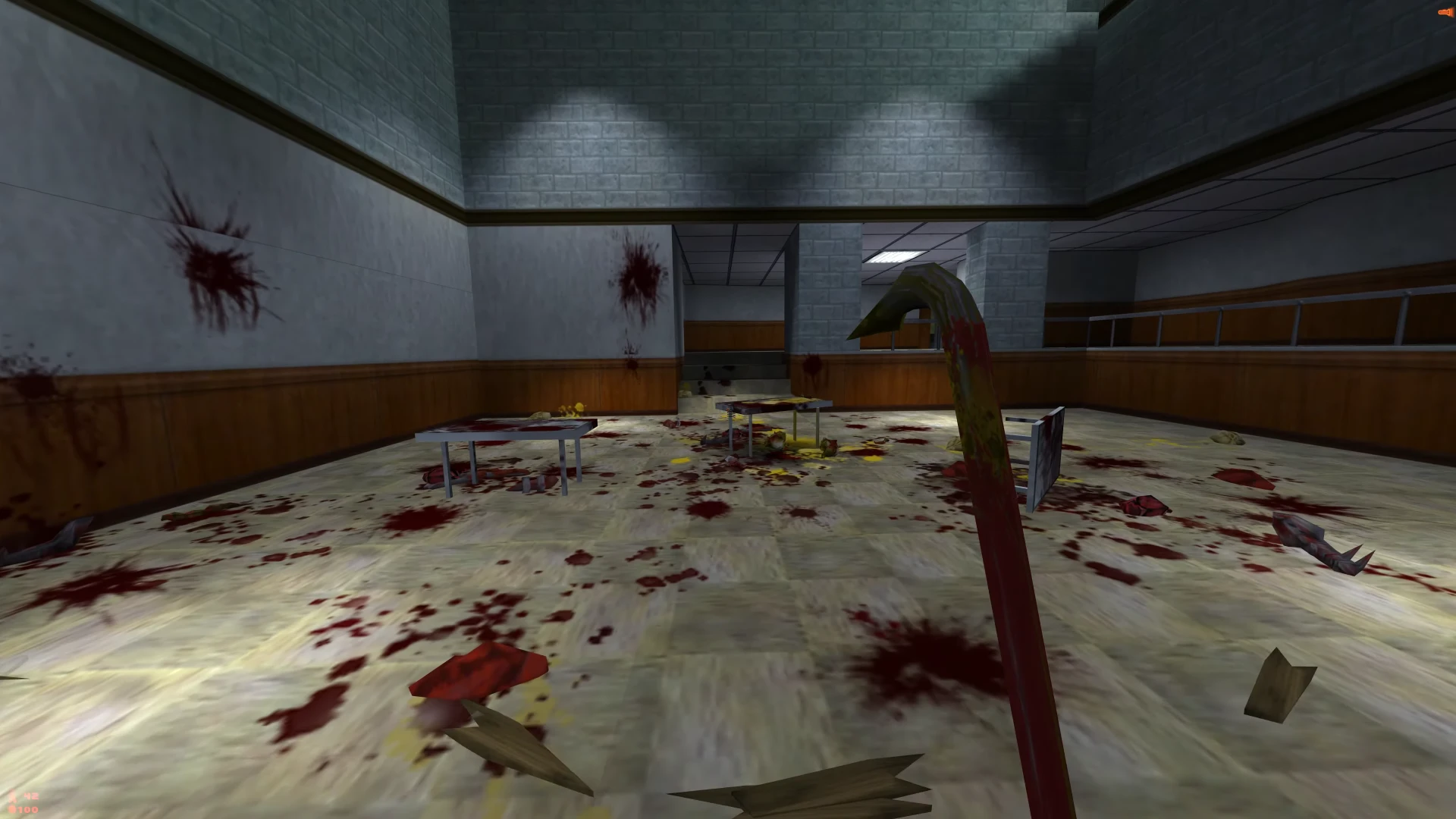 Widok z perspektywy pierwszej osoby na zakrwawiony korytarz w Half-Life z łomem i rozrzuconymi odłamkami