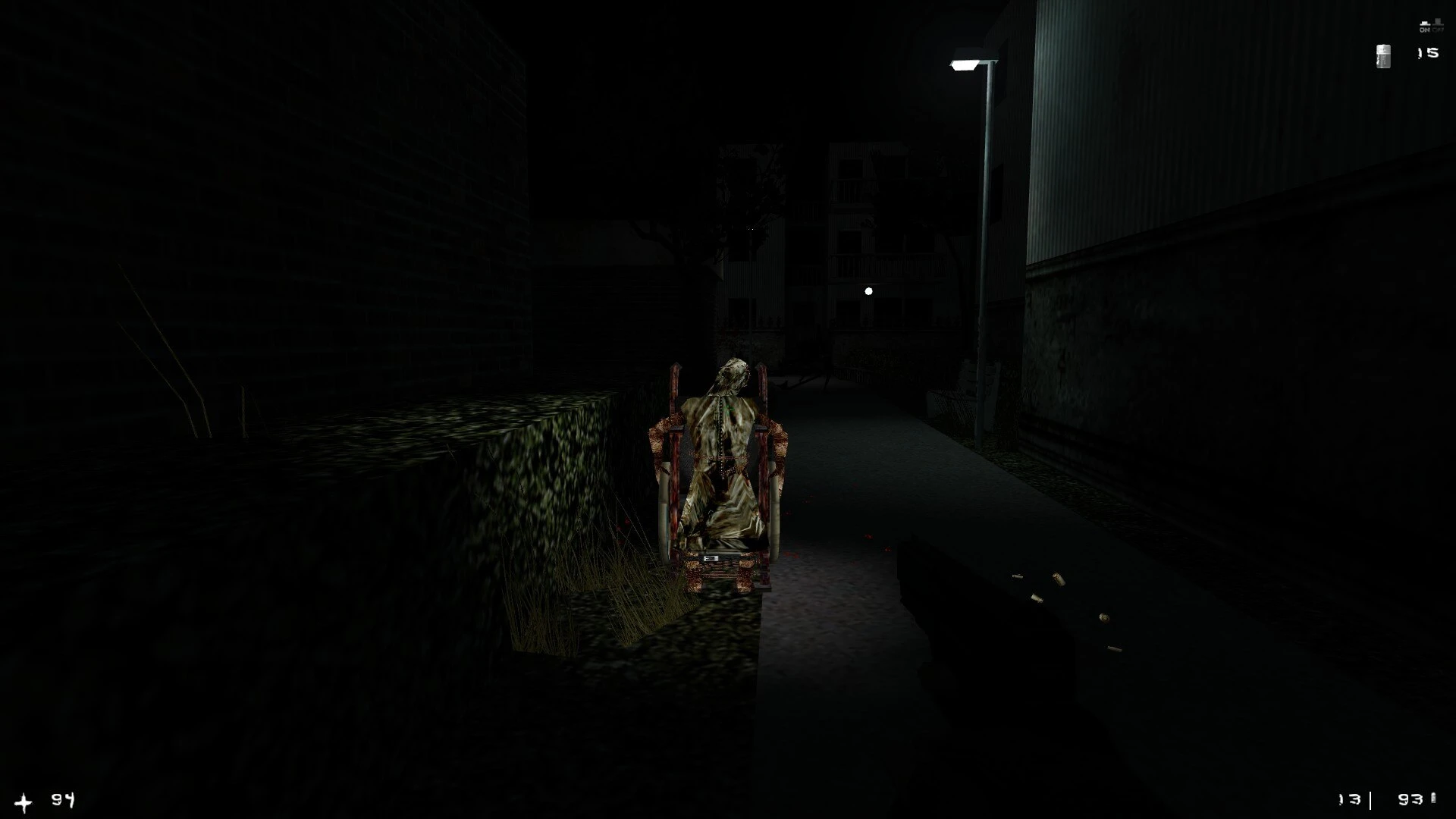 Zrzut ekranu ciemnej ulicy z groteskową postacią na wózku inwalidzkim z moda Half-Life Afraid of Monsters Director's Cut