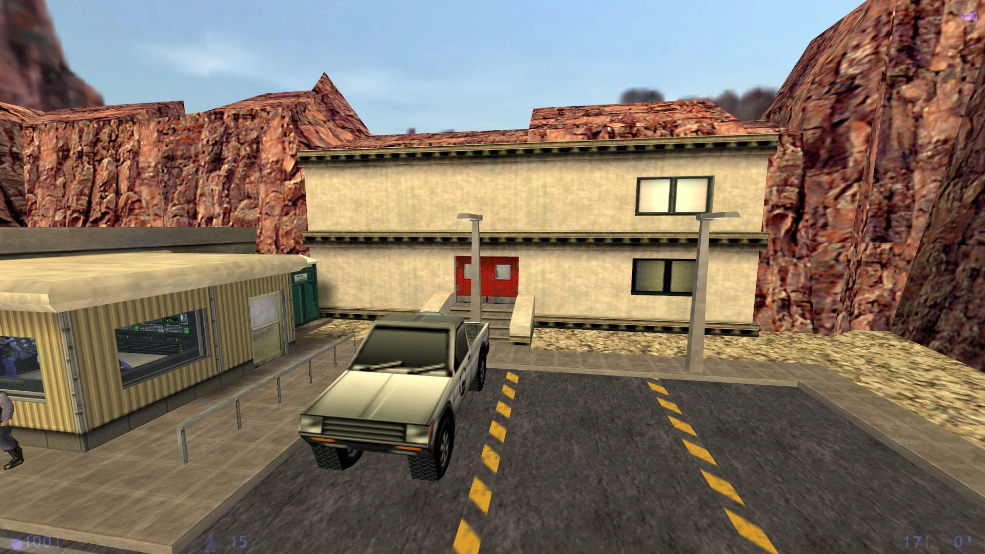 Zrzut ekranu Half-Life 1998 z punktem kontrolnym, ciężarówką obok budynku w skalistym terenie