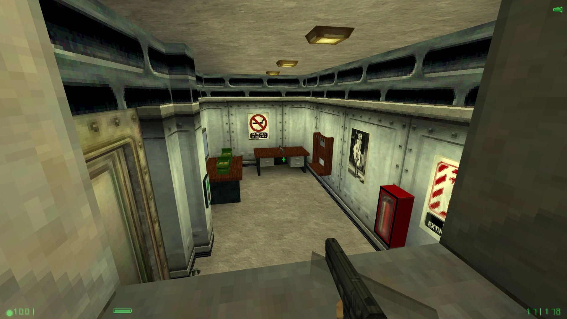 Кімната з моду Half-Life Alpha на рушії GOLDSrc, з столом, постерами та зброєю в руках гравця.