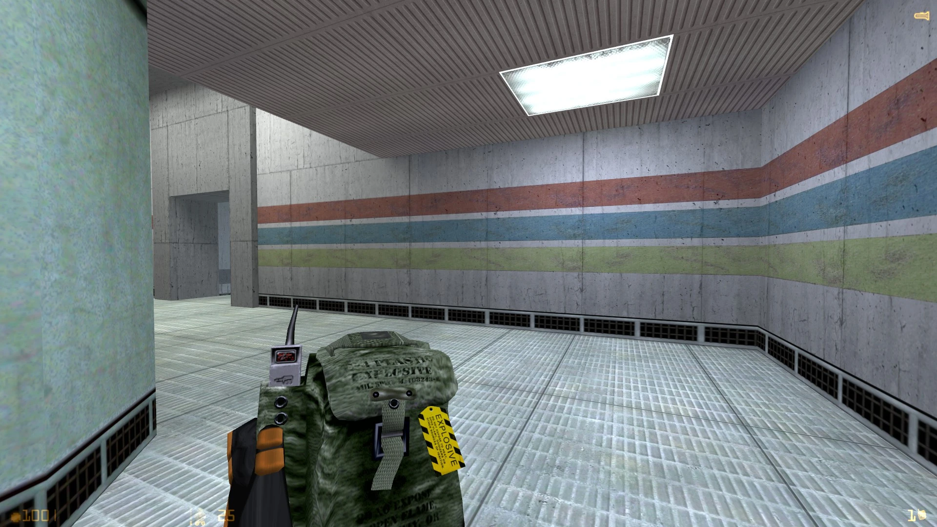Player holding an explosive device labeled with a yellow tag in a tiled industrial hallway in Half-Life mod