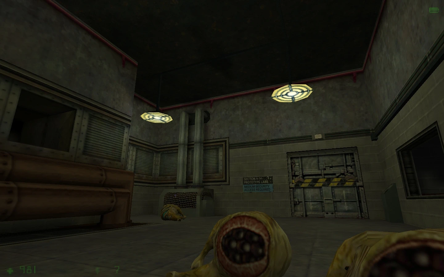 Habitación industrial poco iluminada con paredes metálicas y criaturas alienígenas caídas en el mod Half-Life