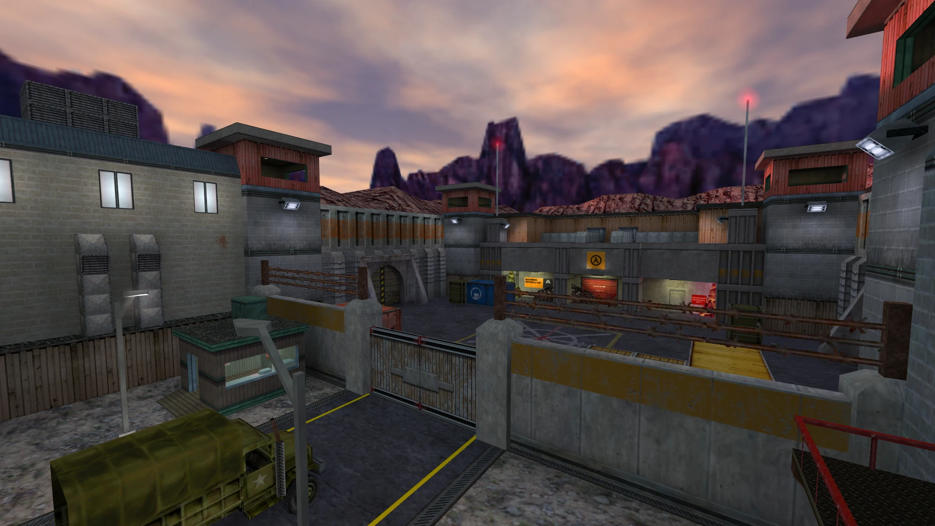 Blick auf einen befestigten Komplex mit Wachtürmen, Barrieren, Militärlastwagen und Bergkulisse im Half-Life Insecure Mod