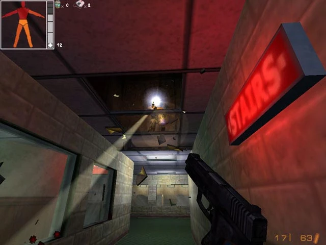 Jugador con pistola en un pasillo con poca luz bajo un letrero rojo STAFF