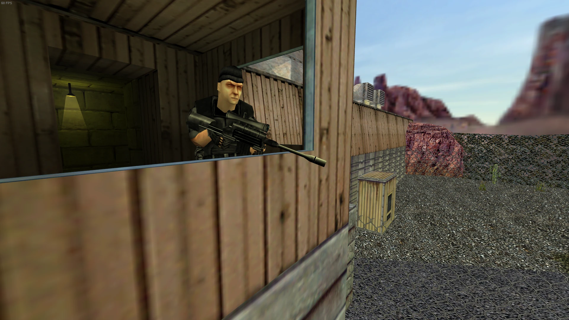 Captura de pantalla mostrando a un soldado con rifle francotirador dentro de una torre de vigilancia de madera que vigila un área al aire libre cercada con terreno rocoso en Half-Life Sudden Invasion