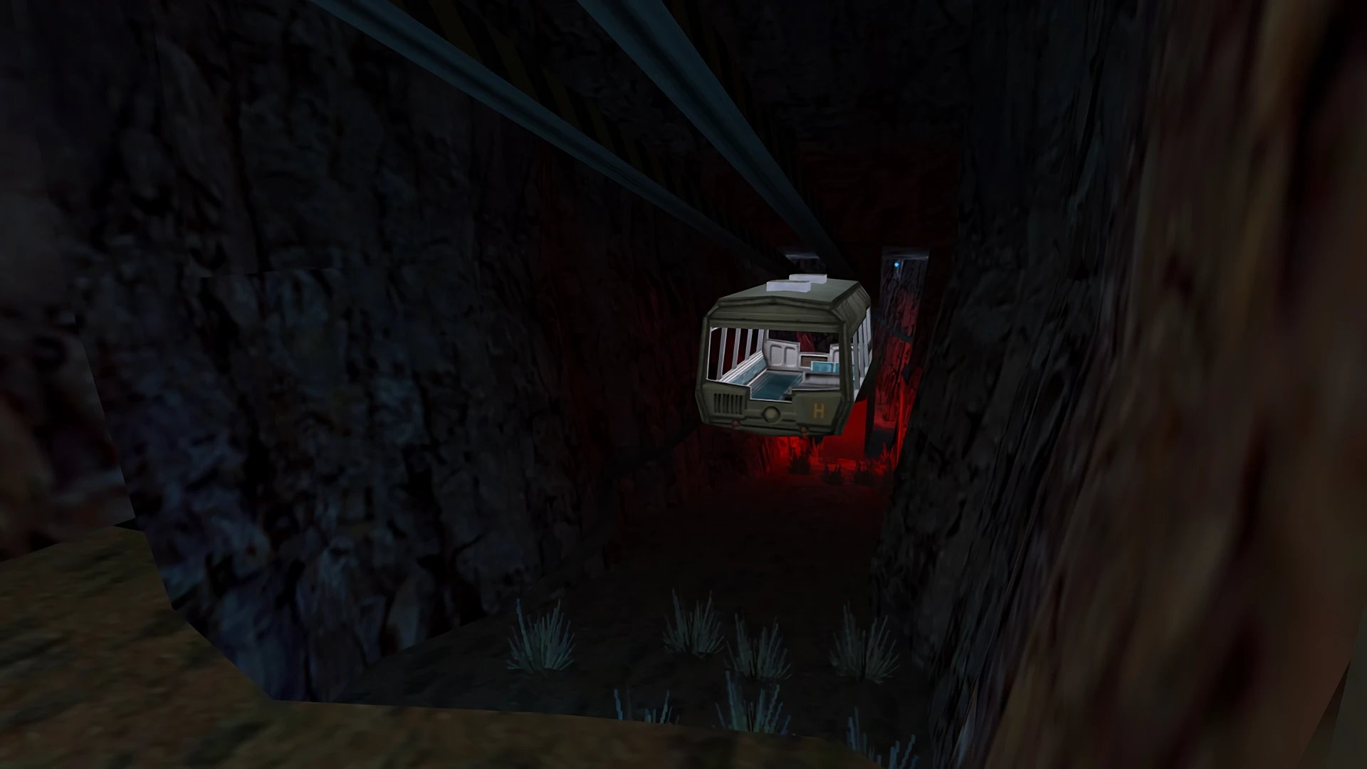 Captura de pantalla del juego con un teleférico dentro de un oscuro túnel subterráneo rocoso con luces rojas