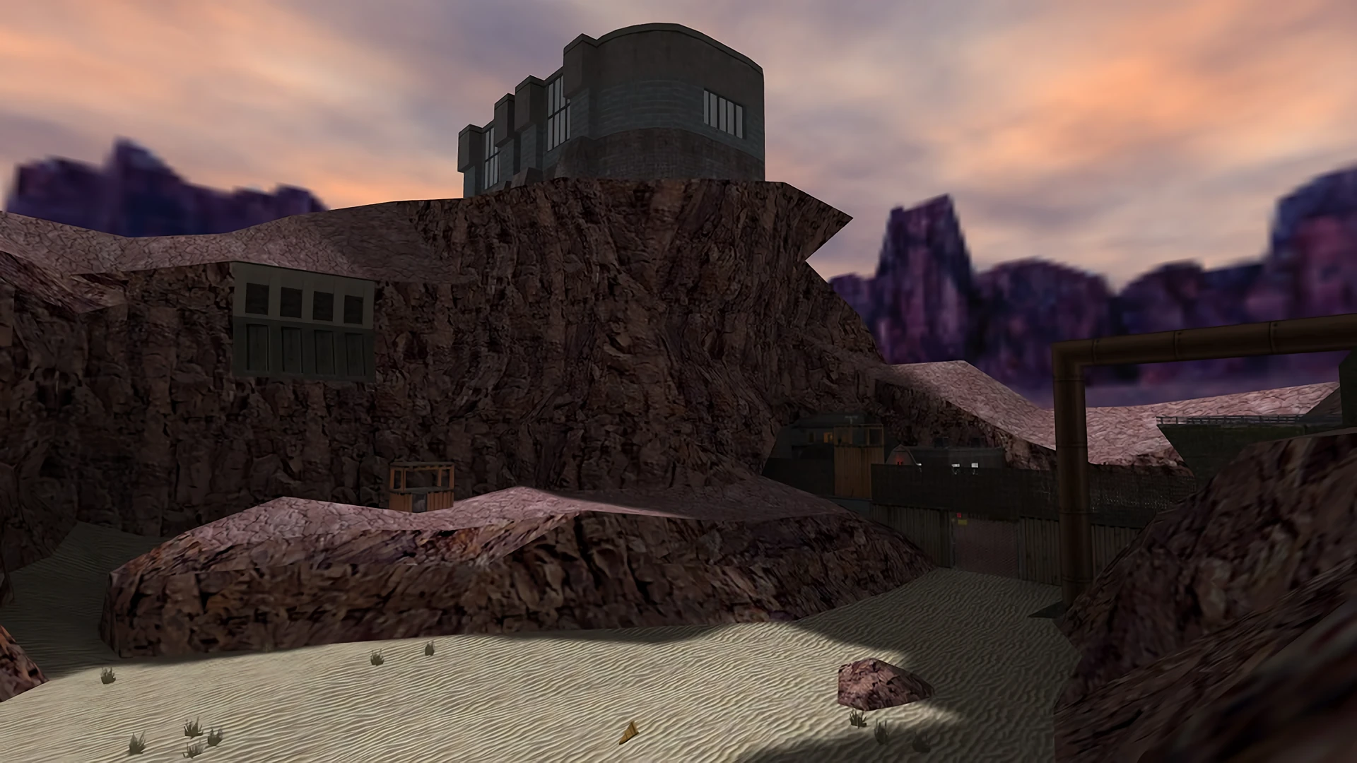 Acantilado rocoso con estructuras en la cima y zona arenosa abajo en el mod Half-Life The Infected