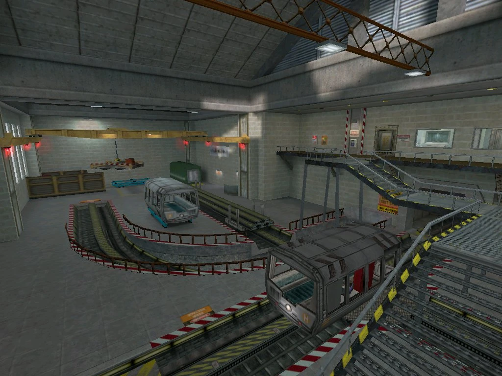 View of an industrial tram running on tracks and a staircase platform in a concrete warehouse interior