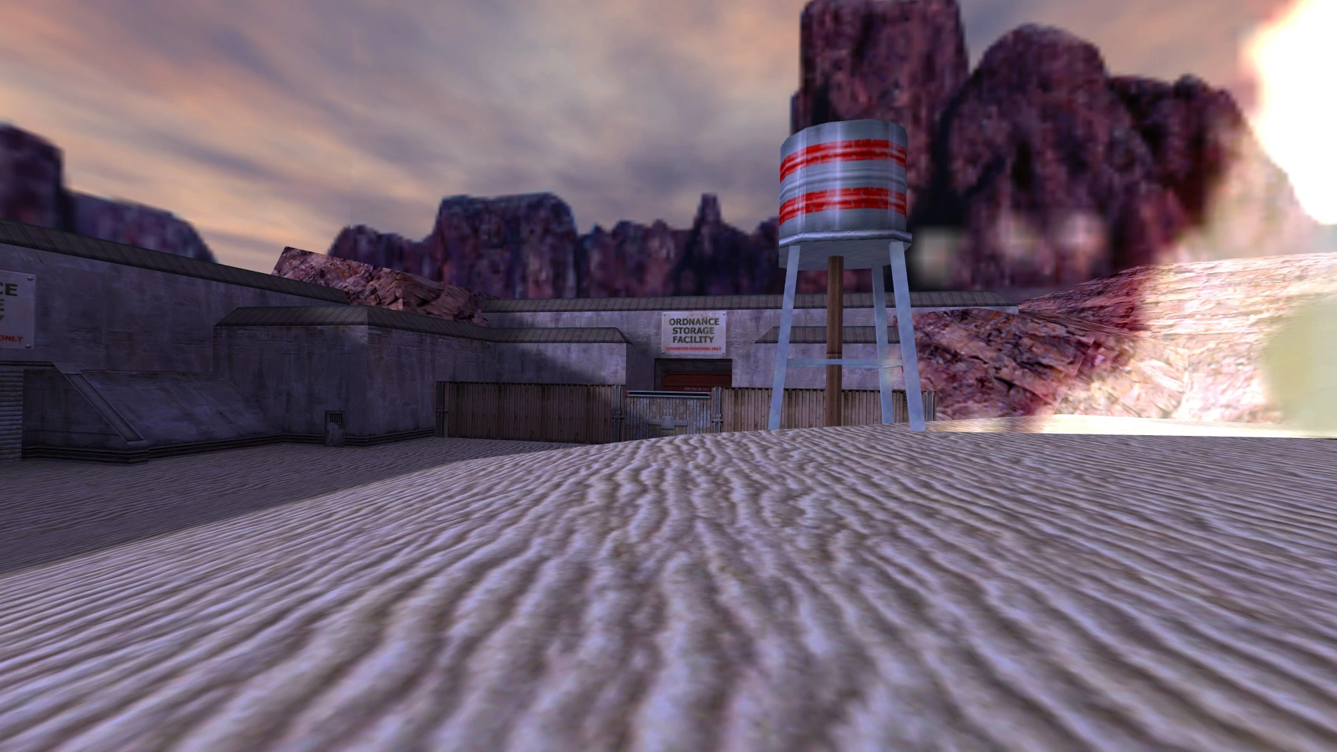 Landscape of sandy terrain with concrete military building and water tower at sunset in Half-Life mod