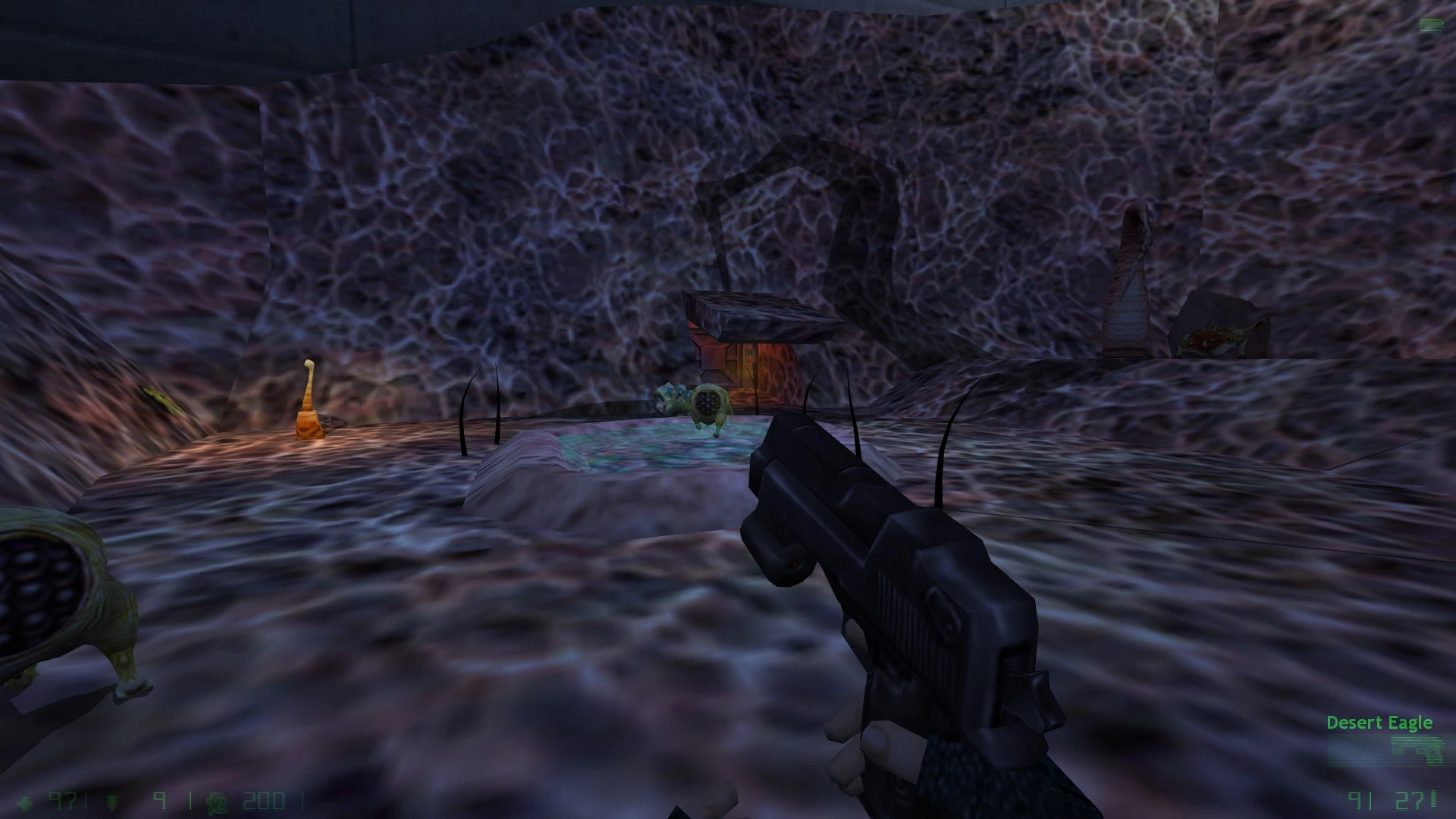First-person view holding Desert Eagle pistol in dark alien cave with strange creatures and glowing textures