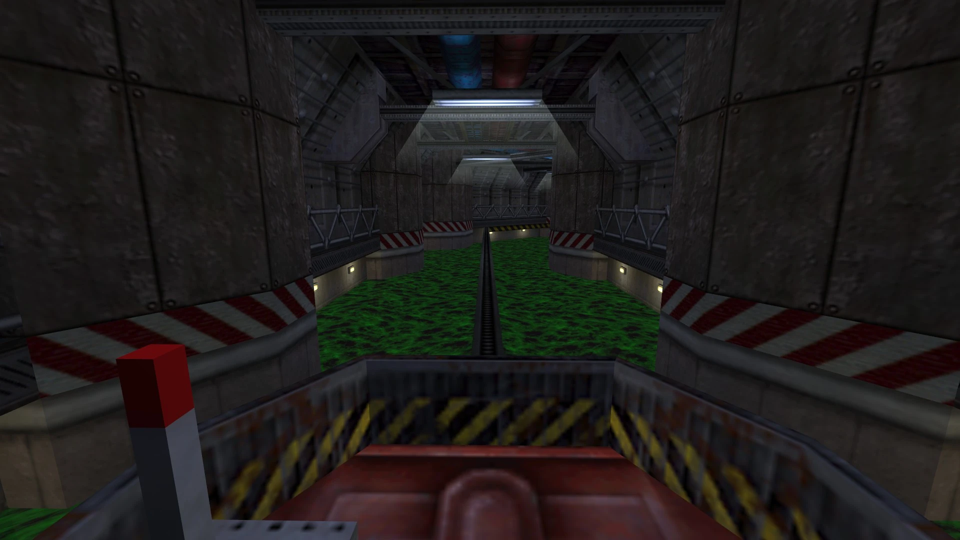 W industrialnym tunelu z toksyczną zieloną cieczą pod czerwono-białą barierką w modzie The Trap do Half-Life