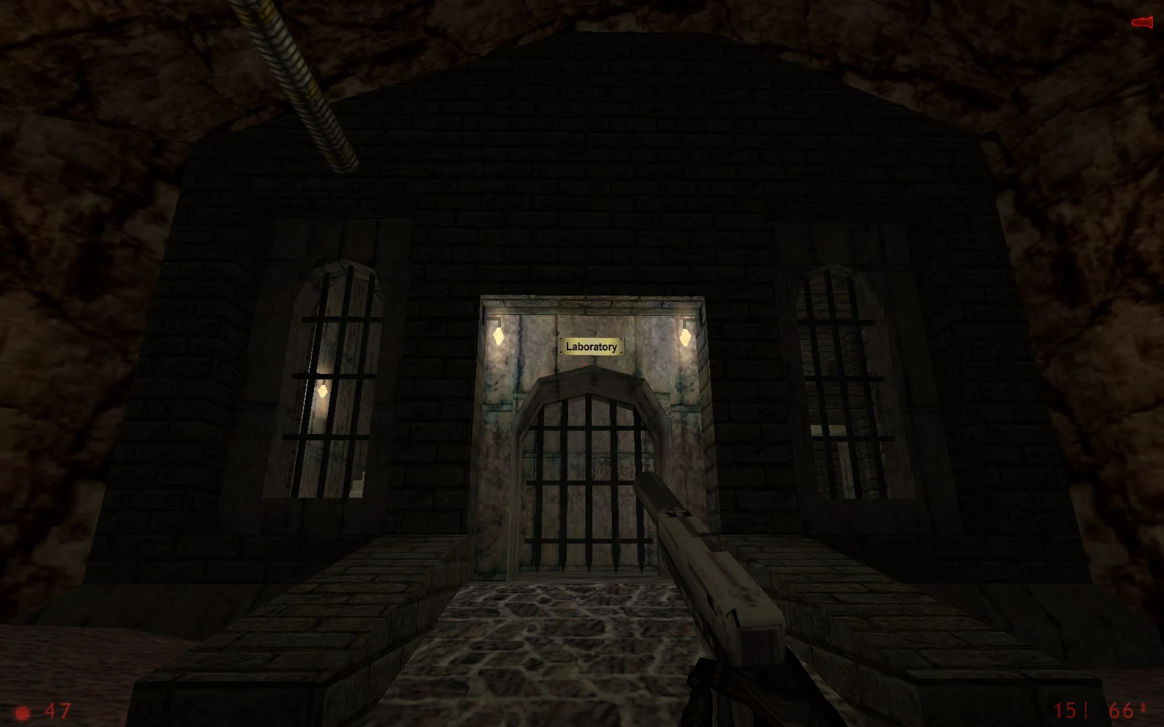 Vista en primera persona de una entrada de laboratorio con rejas en el mod They Hunger Trilogy con pistola en mano