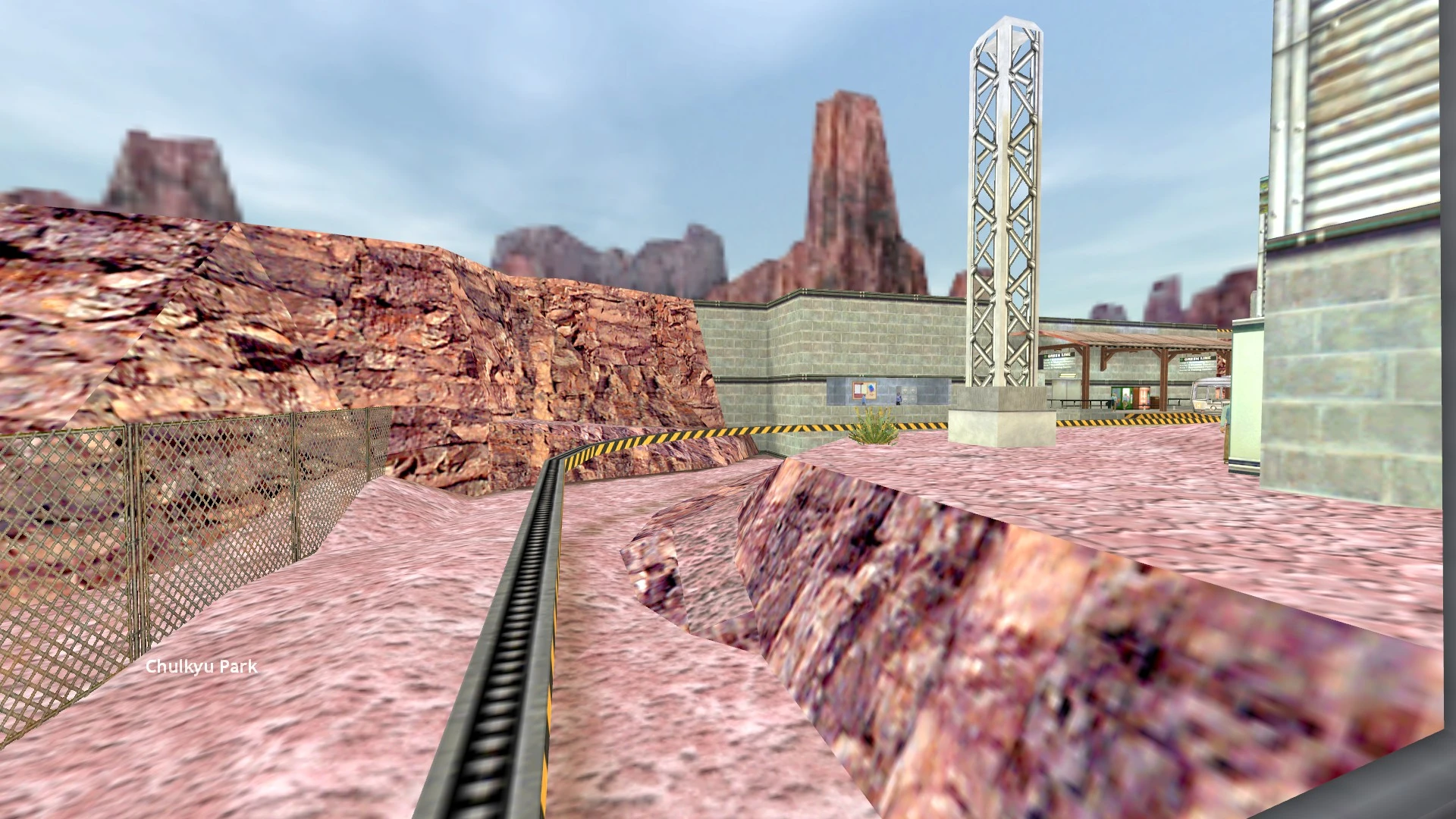 View of a train track running through a rocky canyon area with industrial buildings in the game Half-Life mod Update Residual Point