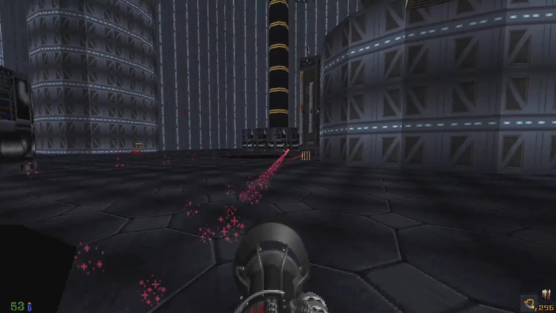 Ігровий вид з темною шестикутною підлогою, циліндричними конструкціями та зброєю, що стріляє червоними енергетичними снарядами