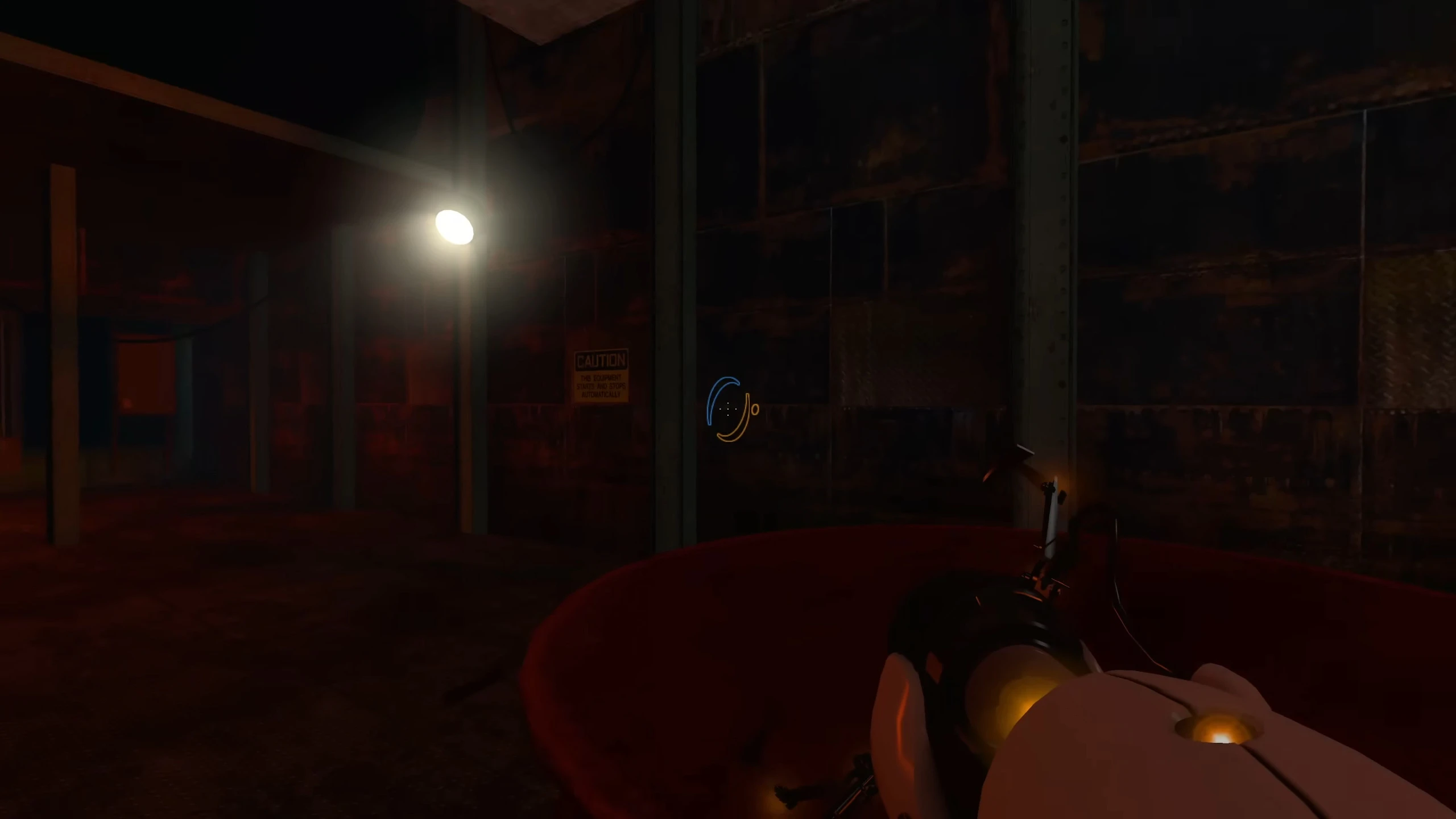 Vista en primera persona de una sala industrial oscura y oxidada con una sola luz, sosteniendo una Portal gun