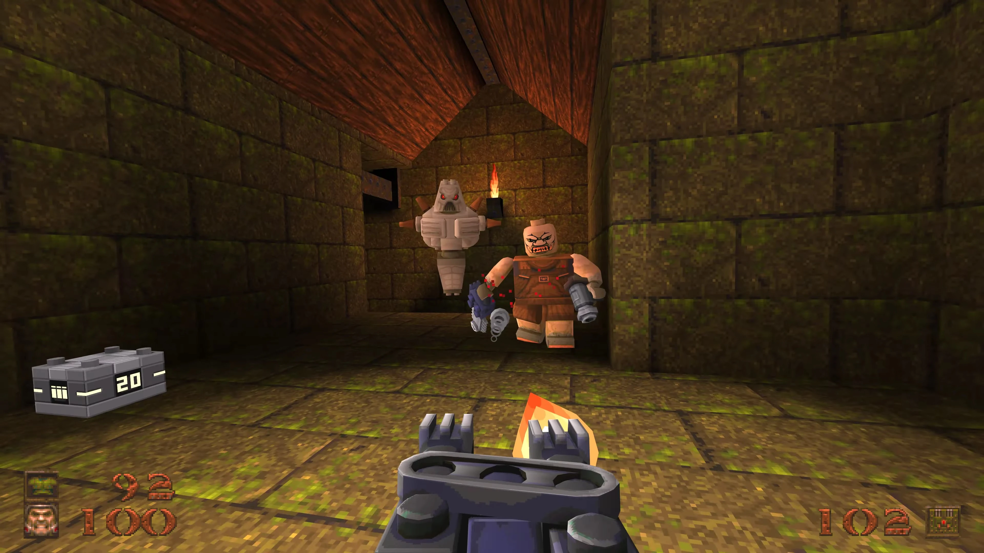Screenshot des Block Quake Mods mit klotzförmigen Gegnern in einem dunklen Steinkorridor und Flammenwerfer-Waffe im Sichtfeld