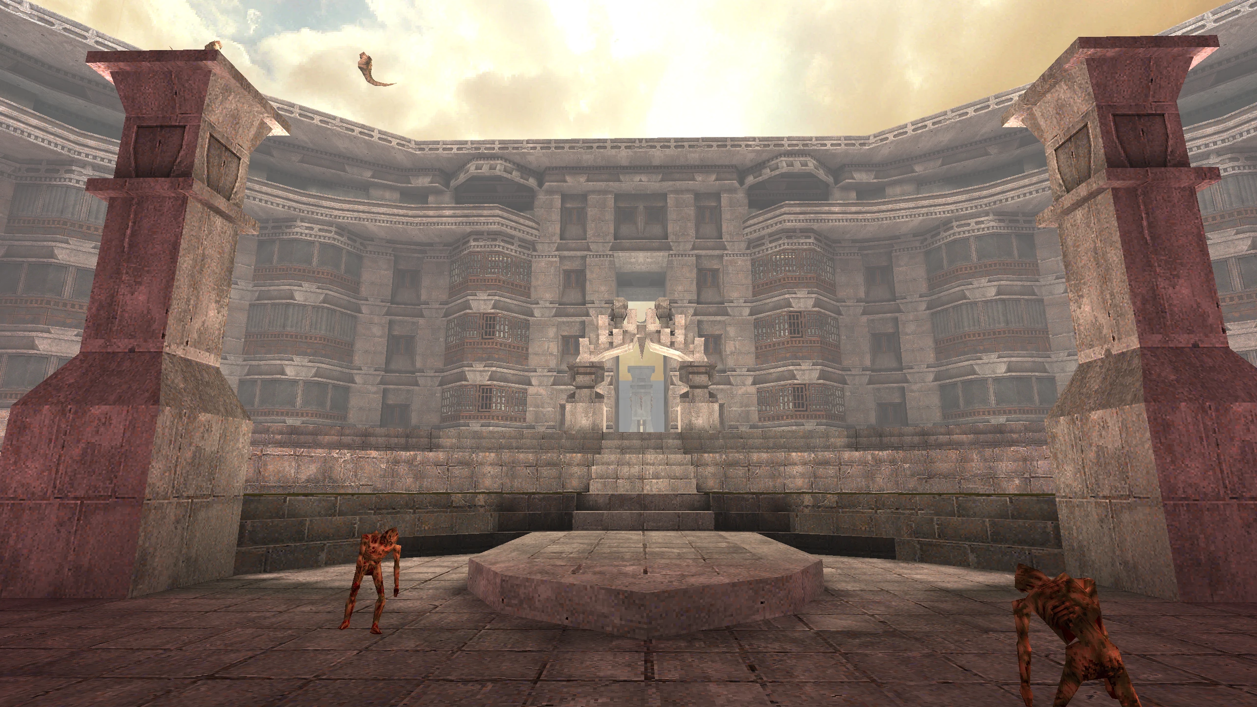 Mod Quake Brutalist Jam przedstawia dużą arenę z brutalistycznymi betonowymi strukturami i dwoma potworami