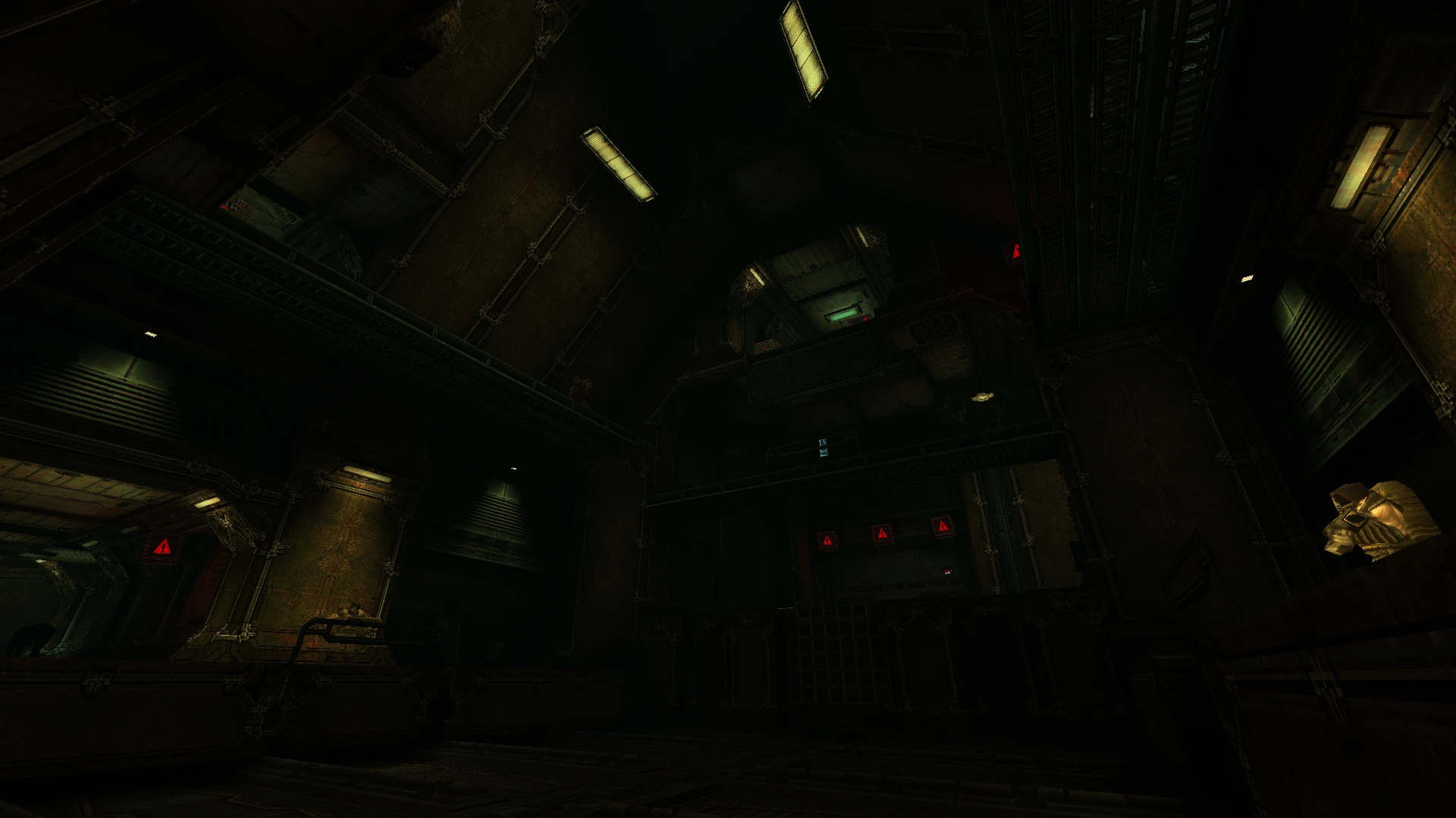 Słabo oświetlona hala przemysłowa ze strukturami metalowymi i czerwonymi znakami ostrzegawczymi w modzie Quake Re:Mobilize