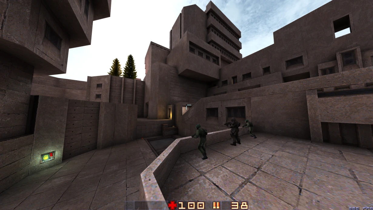 Jugadores navegando un gran complejo de concreto con edificios angulares y árboles bajo un cielo nublado en Quake Sprawl 96