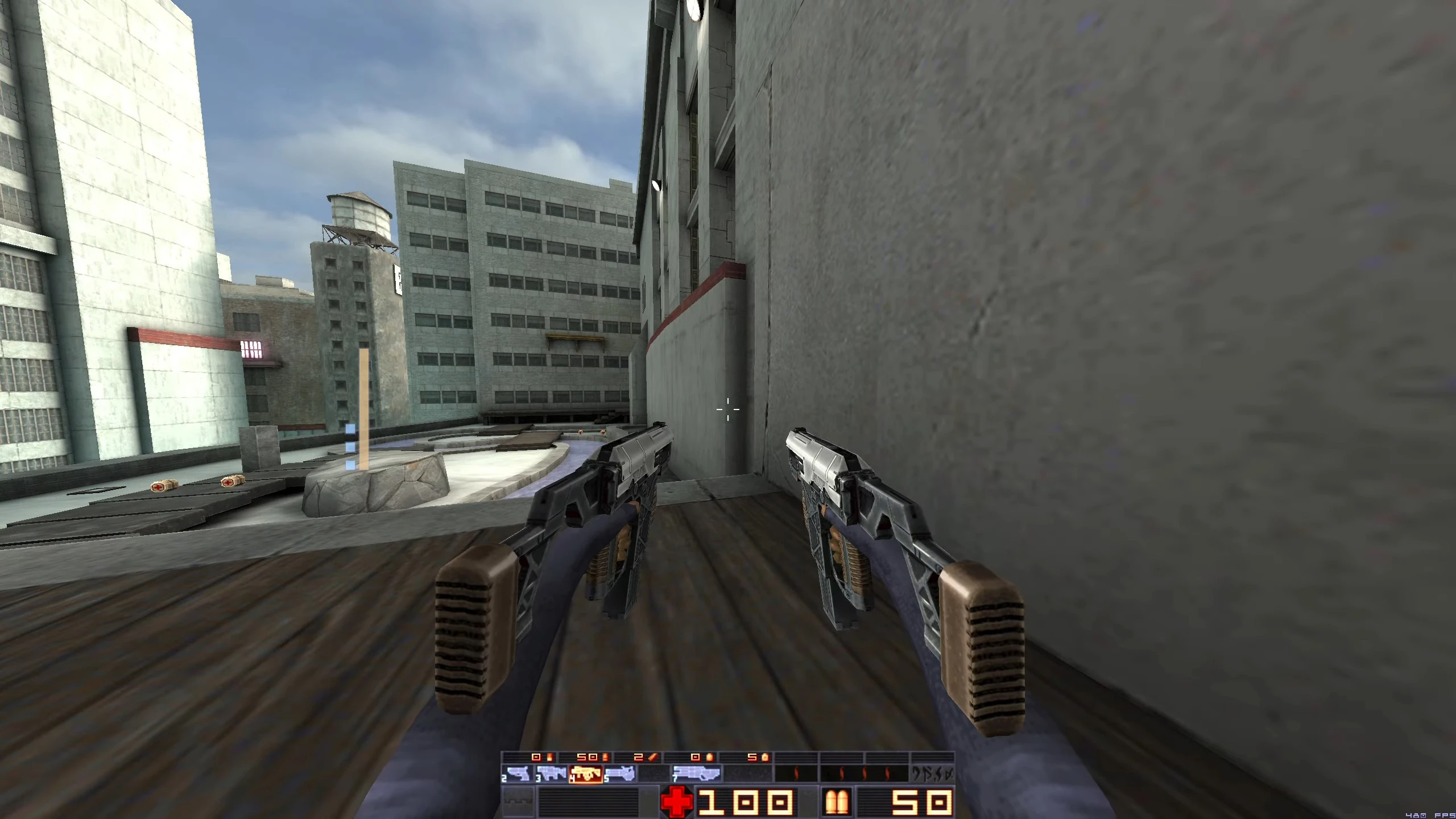 Jugador sosteniendo pistolas dobles en un entorno urbano con edificios altos en el mod Sprawl 96 de Quake