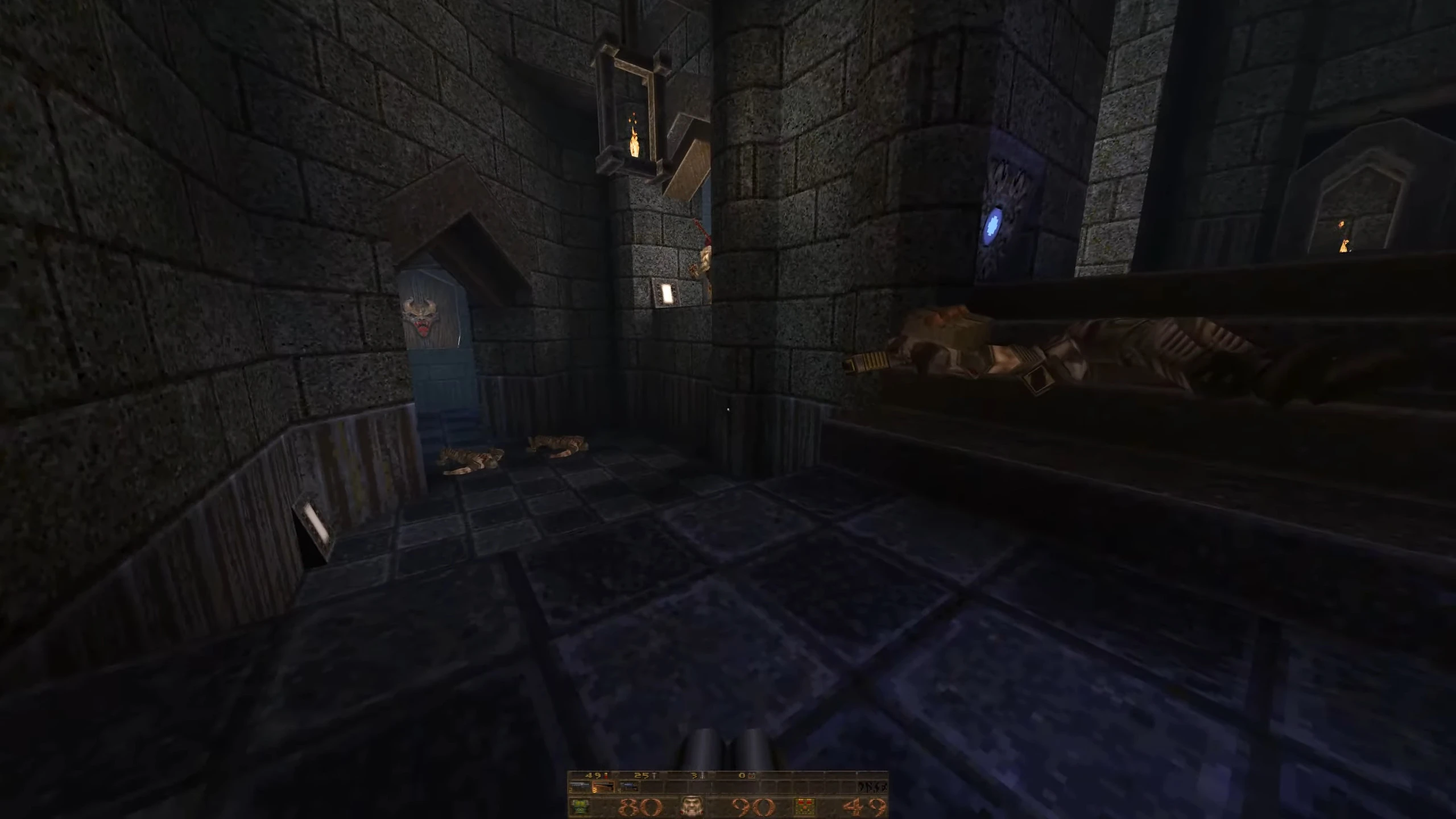 Скриншот из мода Quake Tainted с каменными стенами, синим светящимся символом и несколькими поверженными врагами на полу