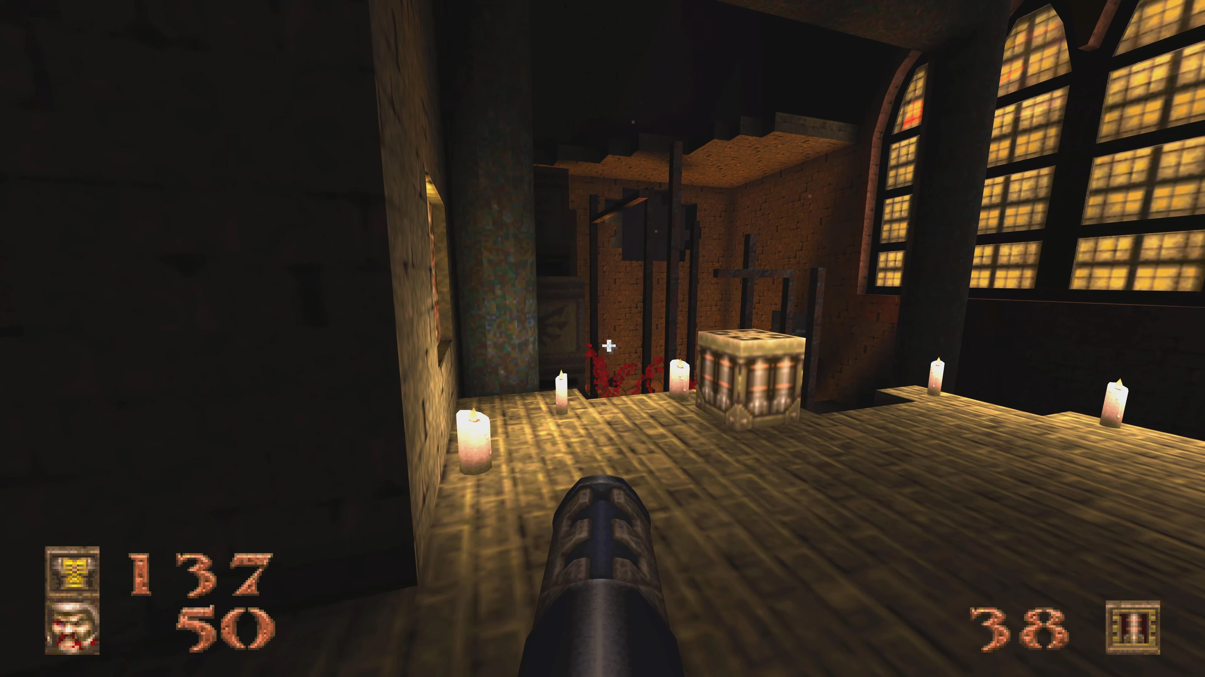 Widok z pierwszej osoby na ciemne wnętrze kaplicy z świecami i bronią w modzie The Spiritworld do Quake