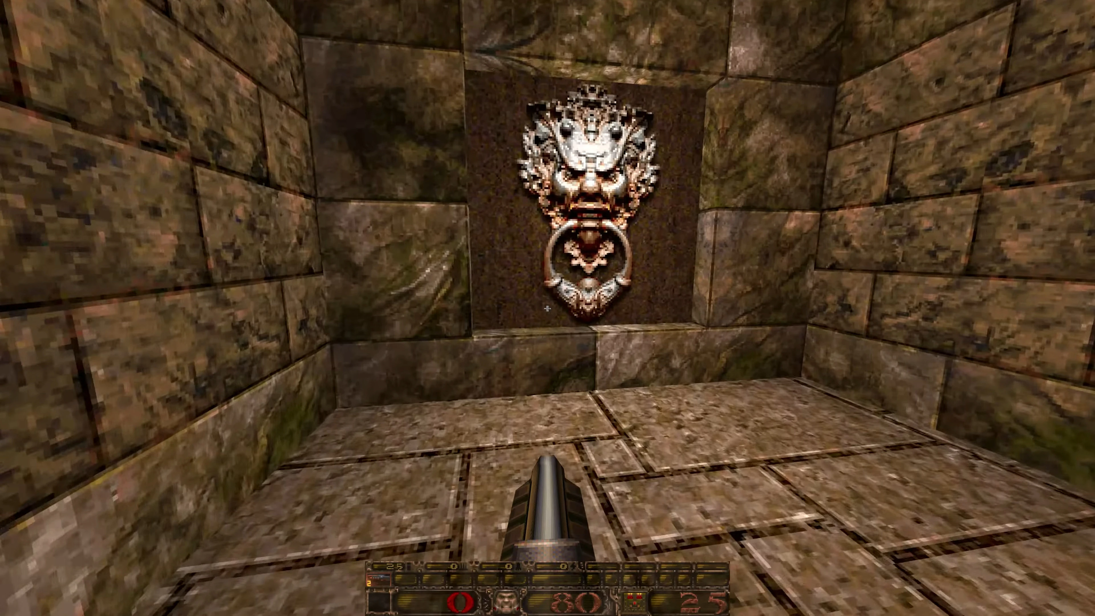 Widok ściany kamiennego pokoju z detaliczną rzeźbą twarzy trzymającą pierścień w ustach w modzie Tomb of Thunder do Quake 1996