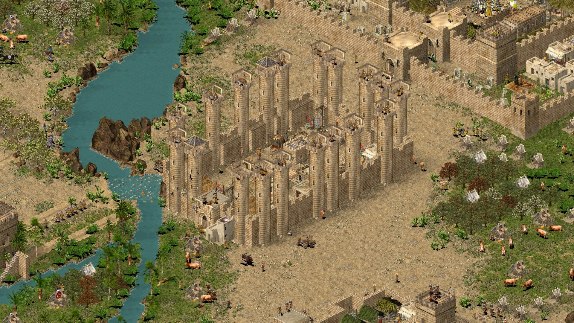 Screenshot aus Stronghold Crusader mit einer großen Wüstenstadt mit Mauern und Türmen