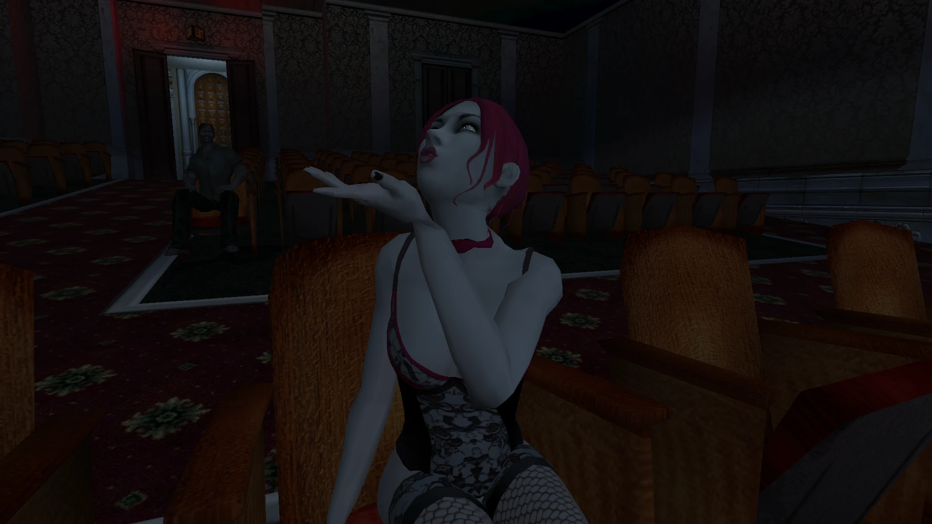 Mujer vampiro con cabello rojo y atuendo negro con encaje sentada en una silla de teatro enviando un beso, interior oscuro